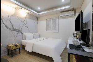 a white bedroom with a white bed and a desk at Yeon Stay in Seoul