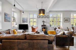 a living room with a leather couch and a fireplace at 0057-Romo-Juvrevej-49 in Høm