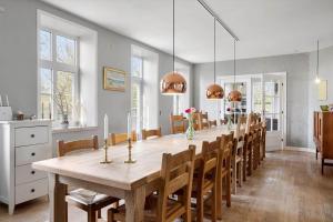 a large dining room with a long table and chairs at 0057-Romo-Juvrevej-49 in Høm