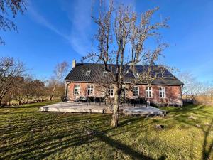 a large brick house with a tree in the yard at 0057-Romo-Juvrevej-49 in Høm