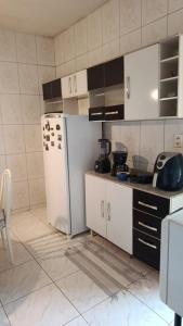 a kitchen with a white refrigerator in a room at Casa Conforto e Aconchego com garagem e internet próximo ao centro in Pesqueira