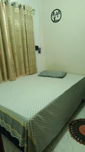 a bed in a room with curtains and a bed sidx sidx sidx at Casa Conforto e Aconchego com garagem e internet próximo ao centro in Pesqueira