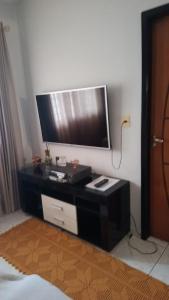 a living room with a tv on a wall at Casa Conforto e Aconchego com garagem e internet próximo ao centro in Pesqueira