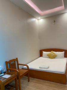 a bedroom with a bed and a table and a chair at Hoàng Long 2 Hotel in Chúc Sơn