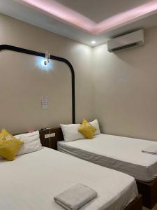 two beds in a room with a pink ceiling at Hoàng Long 2 Hotel in Chúc Sơn +6 photos