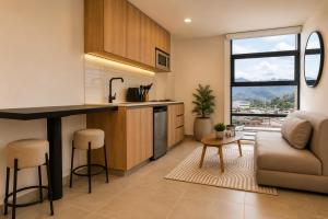 a kitchen and living room with a couch and a table at Metropolitan Living by HOUSY in Medellín
