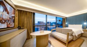 a hotel room with a bed and a large window at Orange Crystal Hotel Kunming Wanda Plaza in Kunming