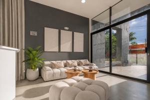 a living room with a white couch and tables at Metropolitan Living by HOUSY in Medellín +47 photos