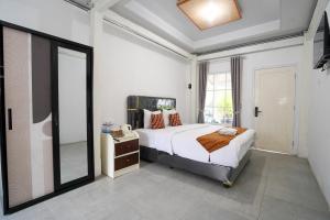 a bedroom with a bed and a large mirror at The Lavana Astungkara in Beran-kidul
