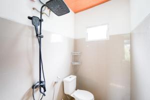 a bathroom with a shower with a toilet in it at The Lavana Astungkara in Beran-kidul +62 photos