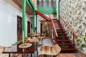 a restaurant with stairs and tables and chairs at Casa Aura Hotel in Bogotá +67 photos