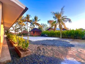 a house with a yard with palm trees and a building at The sonteng hills in Sengkol