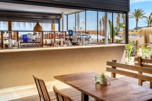 a restaurant with a wooden table and chairs at INNSiDE by Meliá Wave Calviá in Magaluf