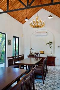 a dining room with tables and chairs and a chandelier at Laman Riverside in Nguyên Ngoại