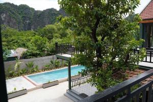 a house with a swimming pool and a tree at Laman Riverside in Nguyên Ngoại