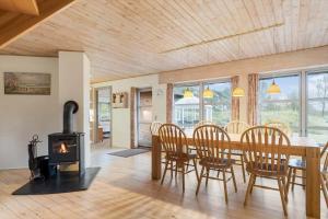 a dining room with a table and a wood stove at 2503-Romo-Hattesvej-38 in Høm