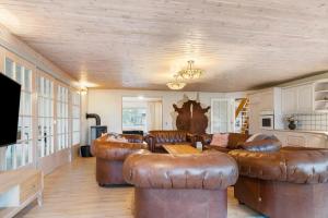 a living room with leather couches and a tv at 2503-Romo-Hattesvej-38 in Høm