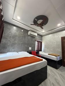 a bedroom with two beds and a ceiling fan at Aditya Residency in Mādhavaram