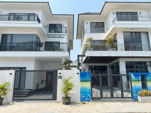 an apartment building with a black gate and plants at Achi Ocean Villa in Cửa Lô