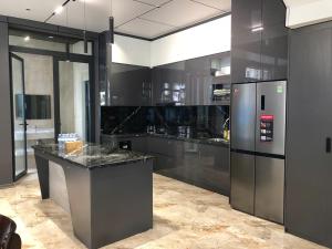 a large kitchen with black cabinets and a refrigerator at Achi Ocean Villa in Cửa Lô