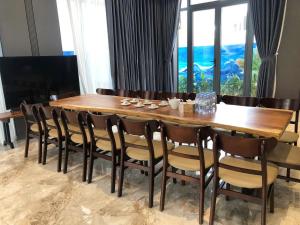 a dining room table with chairs and a large window at Achi Ocean Villa in Cửa Lô