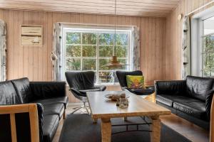 a living room with leather furniture and a table at 2608-Romo-Sonderstrandvej-18 in Høm +32 photos