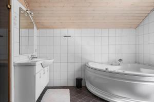 a white bathroom with a tub and a sink at 2608-Romo-Sonderstrandvej-18 in Høm
