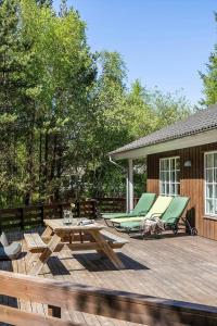 a wooden deck with picnic tables and lounge chairs at 2608-Romo-Sonderstrandvej-18 in Høm
