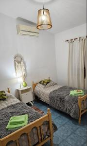 a bedroom with two beds and a lamp at Home Talampaya in Villa Unión