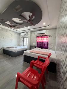 a bedroom with two beds and a ceiling fan at Aditya Residency in Mādhavaram