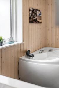 a white bath tub in a room with a window at 2807-Romo-A-Hveyselsvej-28 in Høm +44 photos
