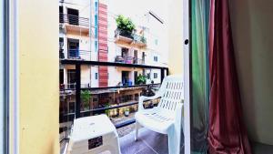 a balcony with a white chair and a window at Vista Residence Patong in Patong Beach