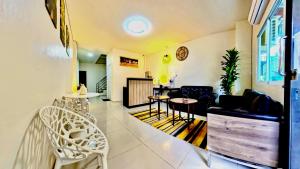 a living room with a couch and a table and chairs at Vista Residence Patong in Patong Beach