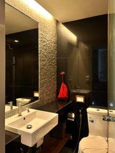a bathroom with a sink and a toilet and a mirror at Varrzon Residence Srinakarin 56 in Bangna +28 photos