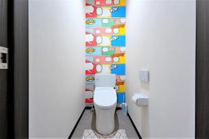 a bathroom with a toilet with a colorful wall at STEP by STEP - Vacation STAY 25753v in Kanayama