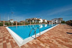 uma grande piscina em frente a algumas casas em Residence Maestrale em Caorle