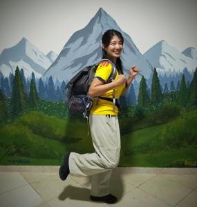 a woman with a backpack standing in front of a mural at Multiverse Hostel in Medellín