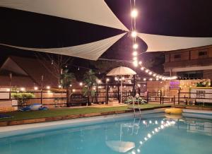 a swimming pool at night with a large umbrella at Pocheon Yolafongta Pension in Pocheon