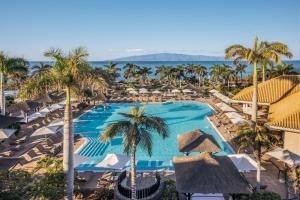 an aerial view of a resort with a pool and palm trees at RedLevel at Gran Meliá Palacio de Isora - Adults Only in Alcalá