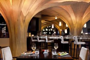 a restaurant with wooden walls and tables with wine glasses at RedLevel at Gran Meliá Palacio de Isora - Adults Only in Alcalá