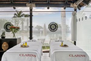 two dining tables with white linens in a restaurant at RedLevel at Gran Meliá Palacio de Isora - Adults Only in Alcalá
