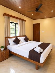 a bedroom with a large white bed with a ceiling at VIVIPRA Habitat, Coorg in Madikeri +13 photos
