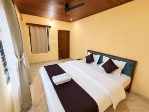 a bedroom with a large bed with white sheets and pillows at VIVIPRA Habitat, Coorg in Madikeri