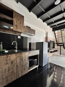 a kitchen with wooden cabinets and a stainless steel refrigerator at Varrzon Residence Srinakarin 56 in Bangna