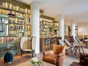 a lobby with chairs and tables and bookshelves at Hotel Colón, a Gran Meliá Hotel - The Leading Hotels of the World in Seville