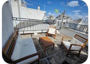 a balcony with two chairs and a table and chairs at Rooftop Maisonette - Old Town by TrulloVista in Martina Franca