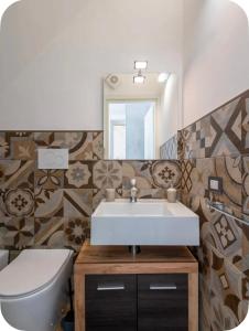 a bathroom with a sink and a toilet and a mirror at Rooftop Maisonette - Old Town by TrulloVista in Martina Franca +39 photos