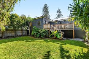 a house with a deck and a yard at THE Elks - Pet Friendly Home in Town - Holiday Yamba in Yamba