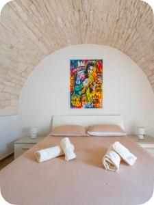 a bedroom with a bed with two towels on it at Rooftop Maisonette - Old Town by TrulloVista in Martina Franca