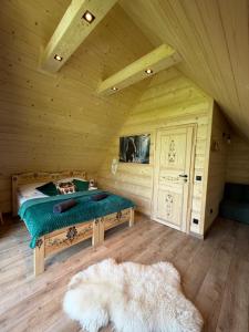 a bedroom with a bed in a wooden room at Domki góralskie Cisza Leśna in Czerwienne